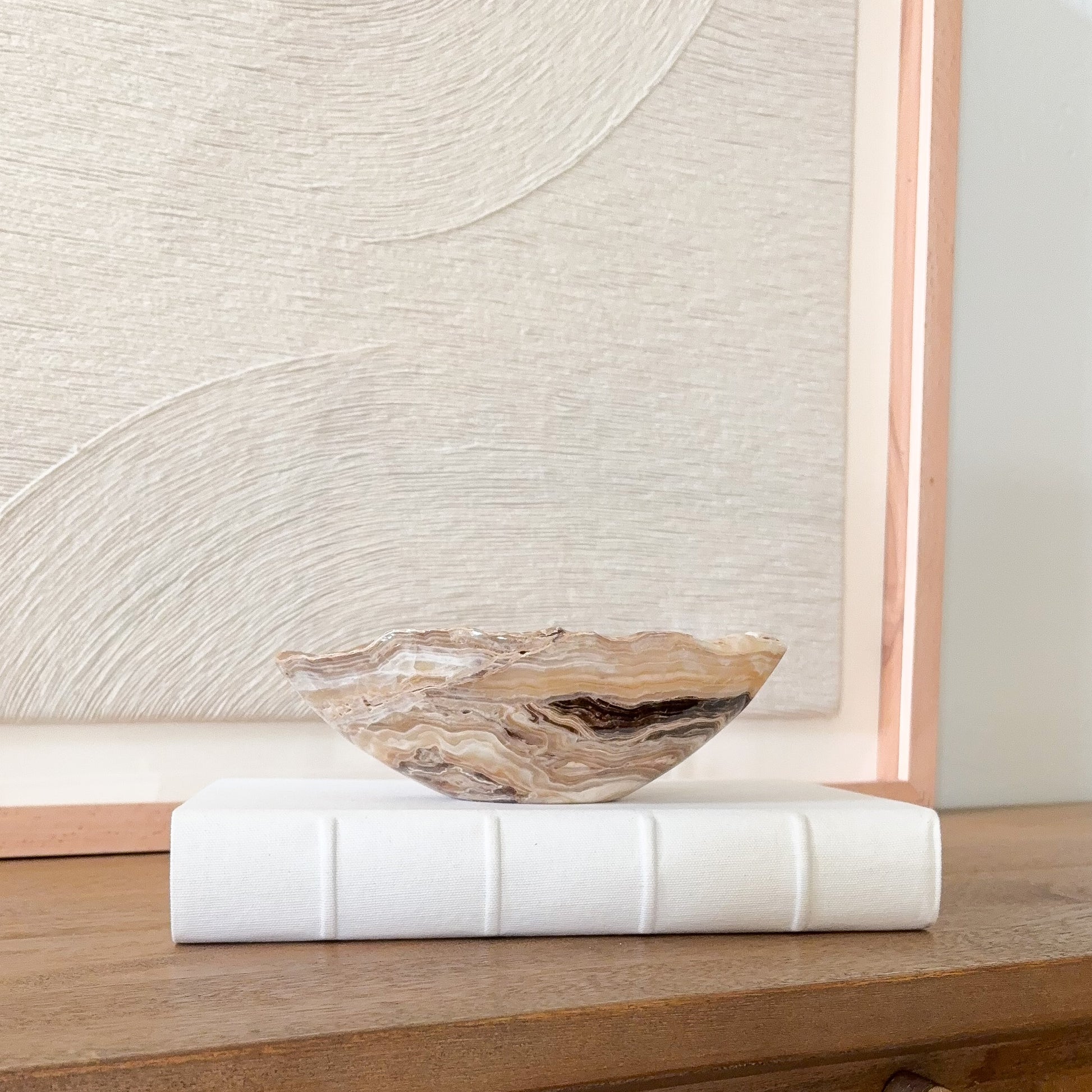 Small hand carved amber onyx bowl with natural stone veining, polished decorative gemstone dish