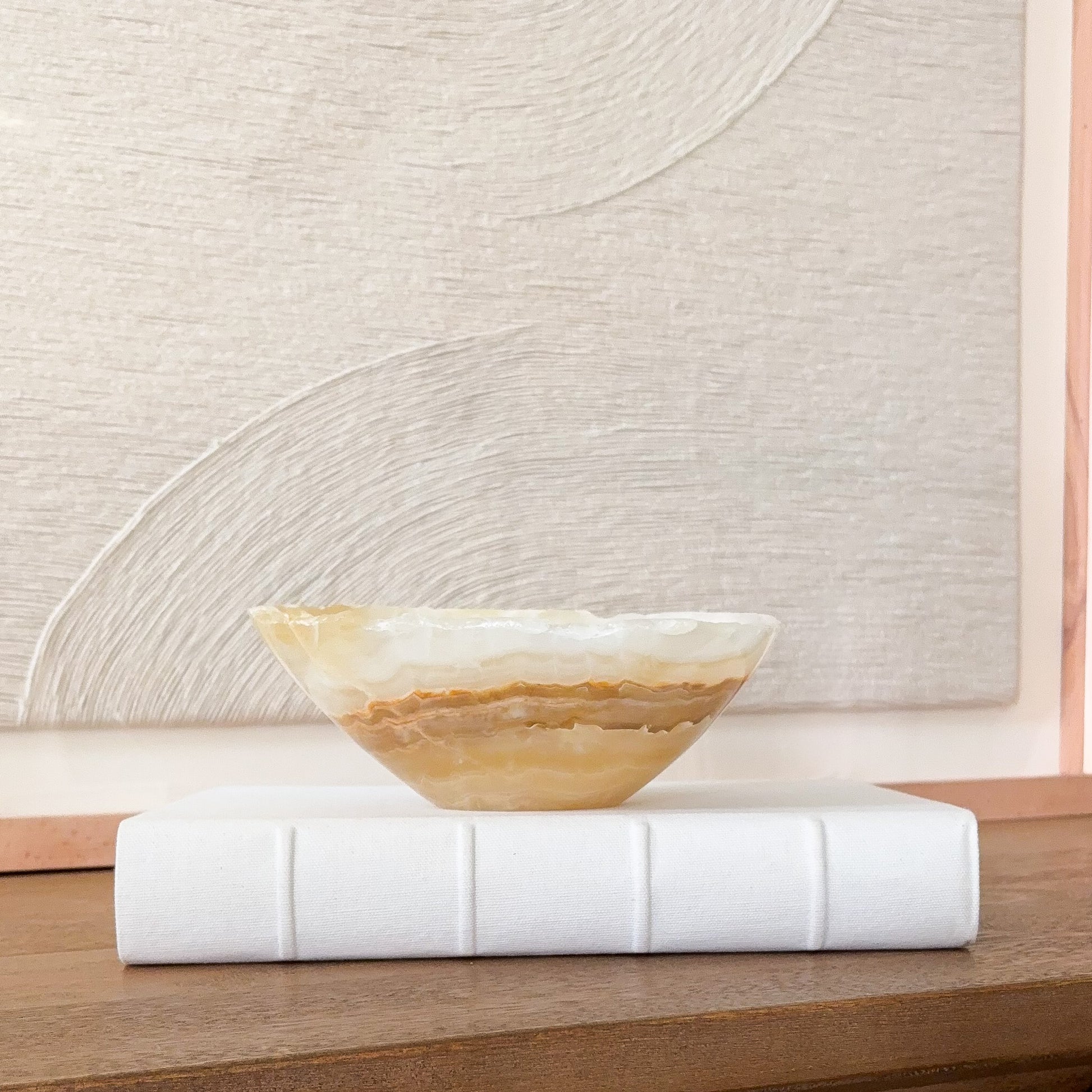 Small hand carved amber onyx bowl with natural stone veining, polished decorative gemstone dish