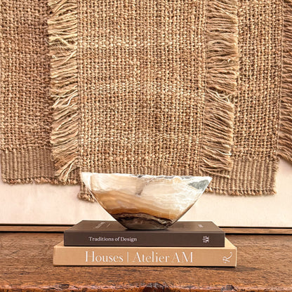Artisan hand-carved amber onyx bowl showcasing unique natural stone patterns and rich golden hues.