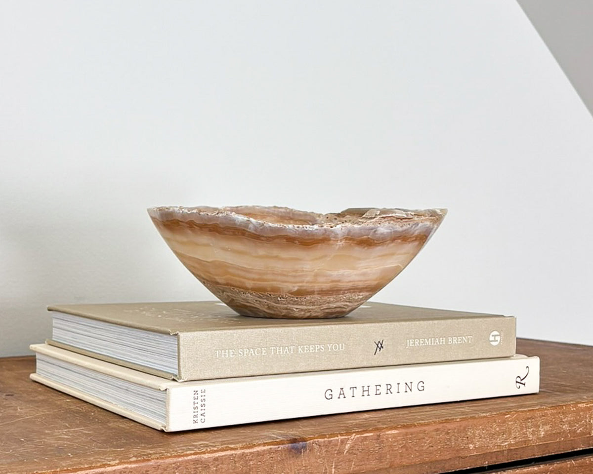 Small amber onyx decorative bowl featuring rich caramel tones and translucent stone