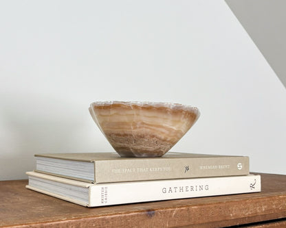 Small natural amber onyx bowl with intricate veining and polished stone finish