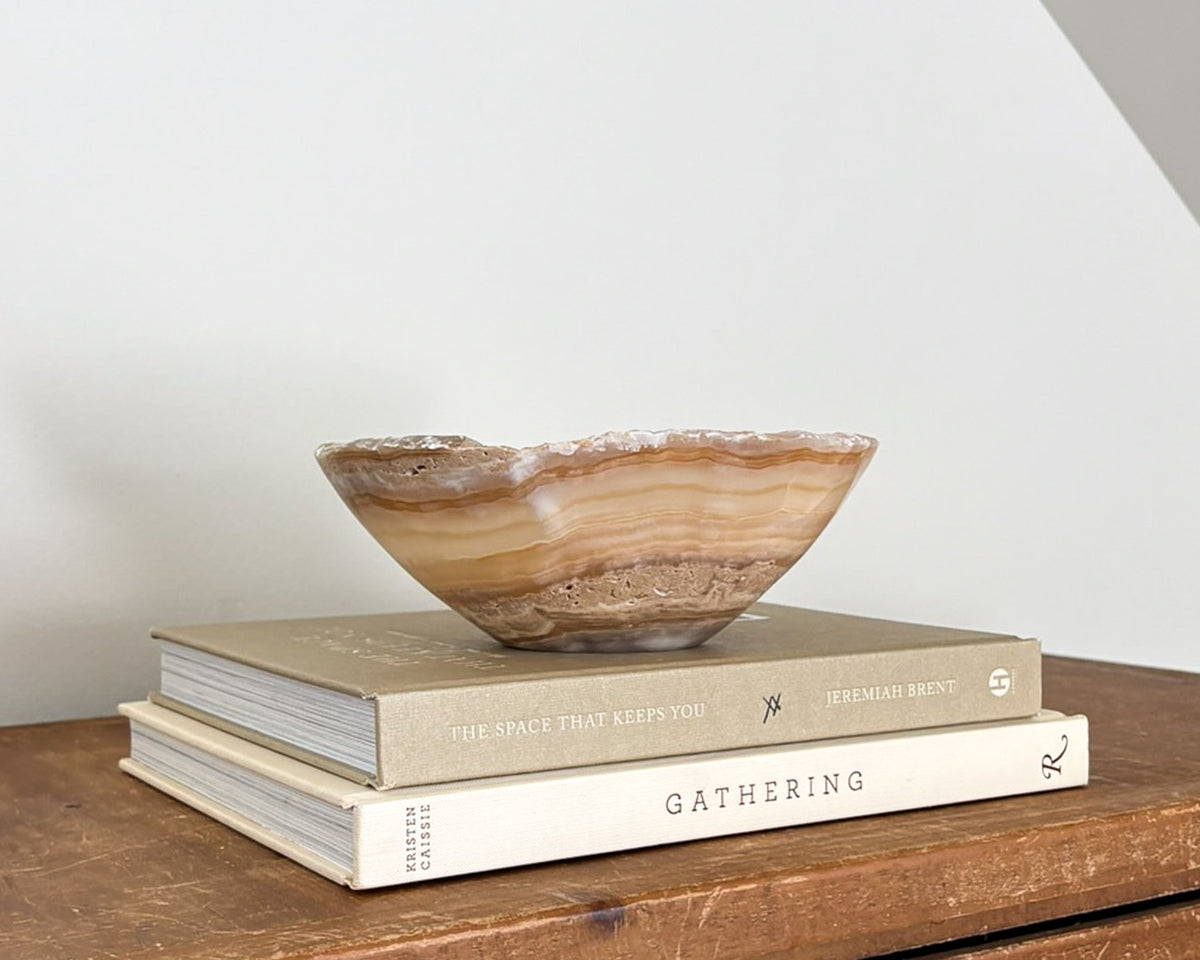 Hand-carved small amber onyx bowl with warm golden hues and distinctive natural banding