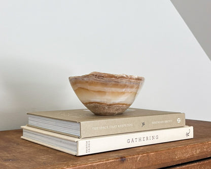 Small natural amber onyx bowl with intricate veining and polished stone finish