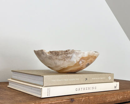 Small amber onyx decorative bowl featuring rich caramel tones and translucent stone