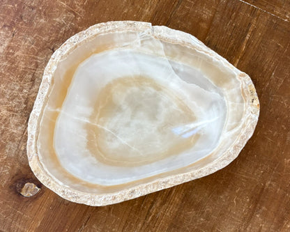 Small decorative amber onyx bowl featuring sculptural form and polished interior