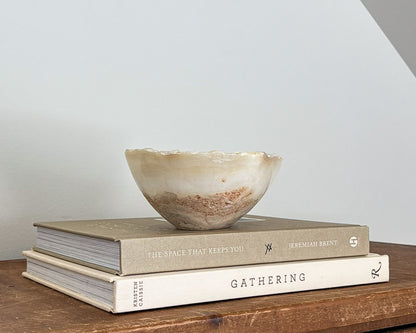 Hand-carved small amber onyx bowl with warm golden hues and distinctive natural banding