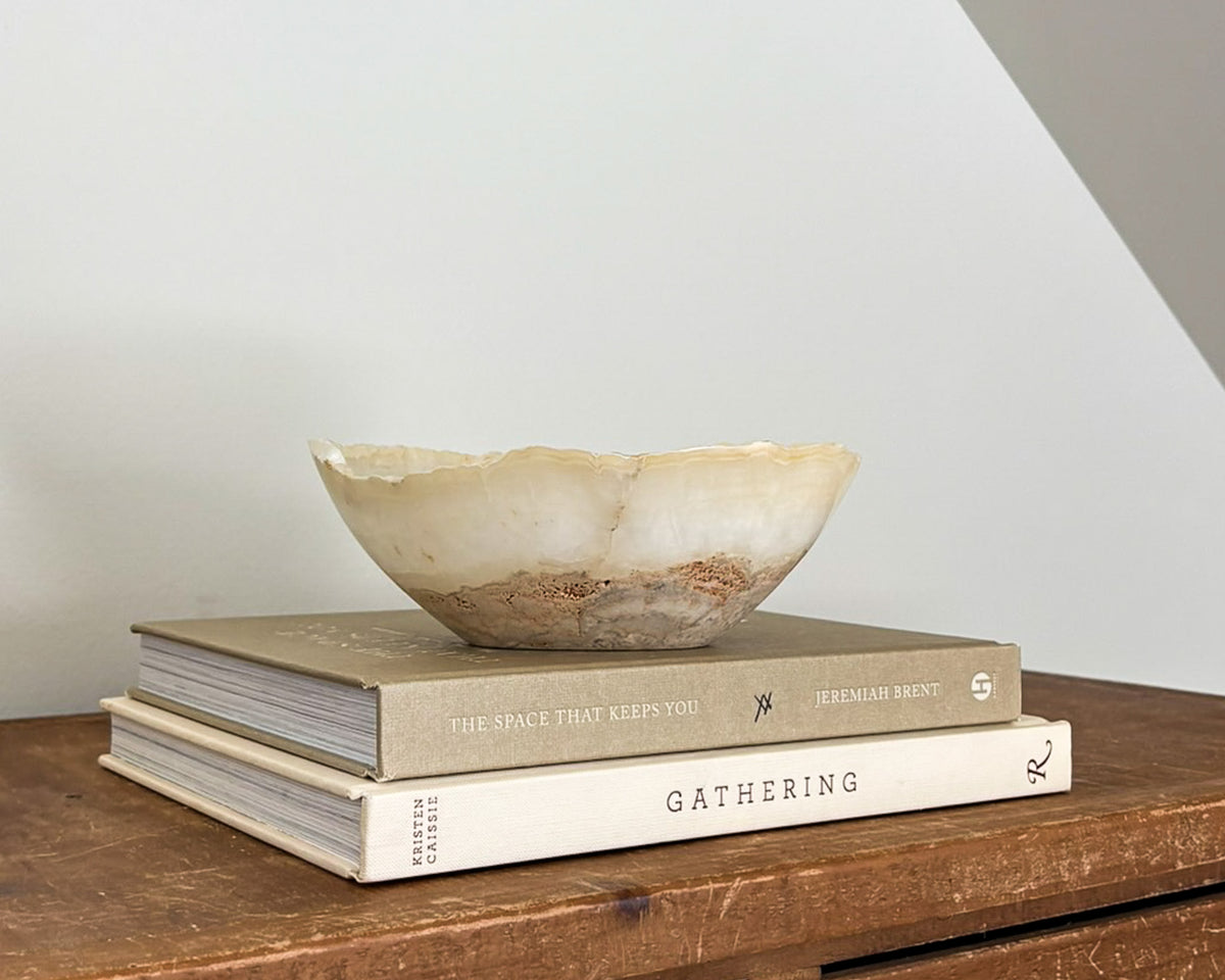 Small amber onyx decorative bowl featuring rich caramel tones and translucent stone