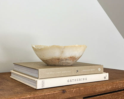 Small amber onyx decorative bowl featuring rich caramel tones and translucent stone