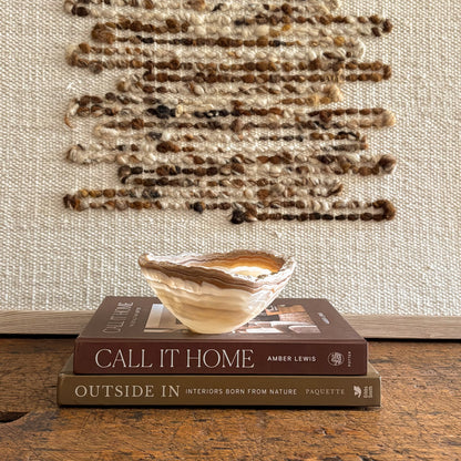 Hand carved amber onyx bowl featuring warm honey and cream stone layers, artisan decorative dish