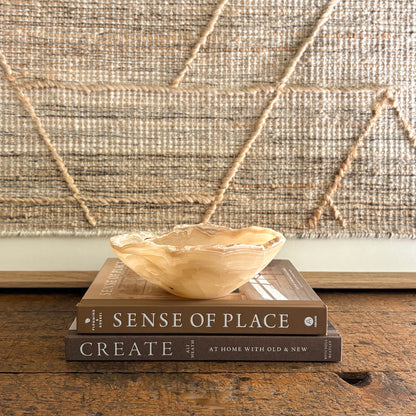Small amber onyx bowl with scalloped edges styled on coffee table books