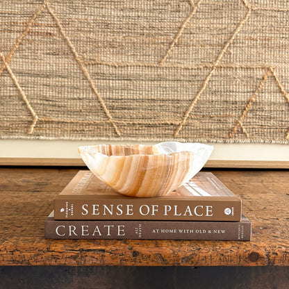 Handcrafted amber onyx stone bowl, glowing light through layered veins