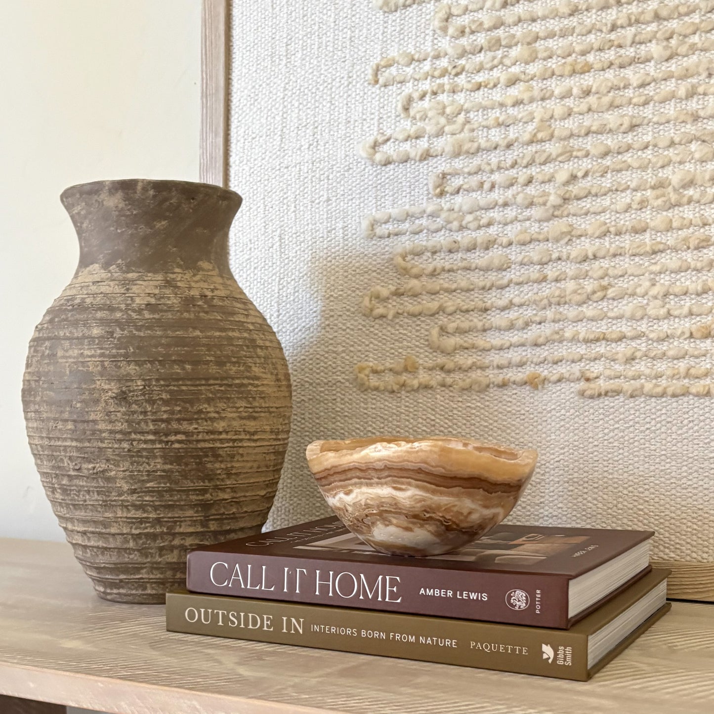 Small polished amber onyx bowl styled on coffee table book