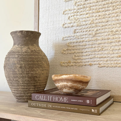 Small polished amber onyx bowl styled on coffee table book
