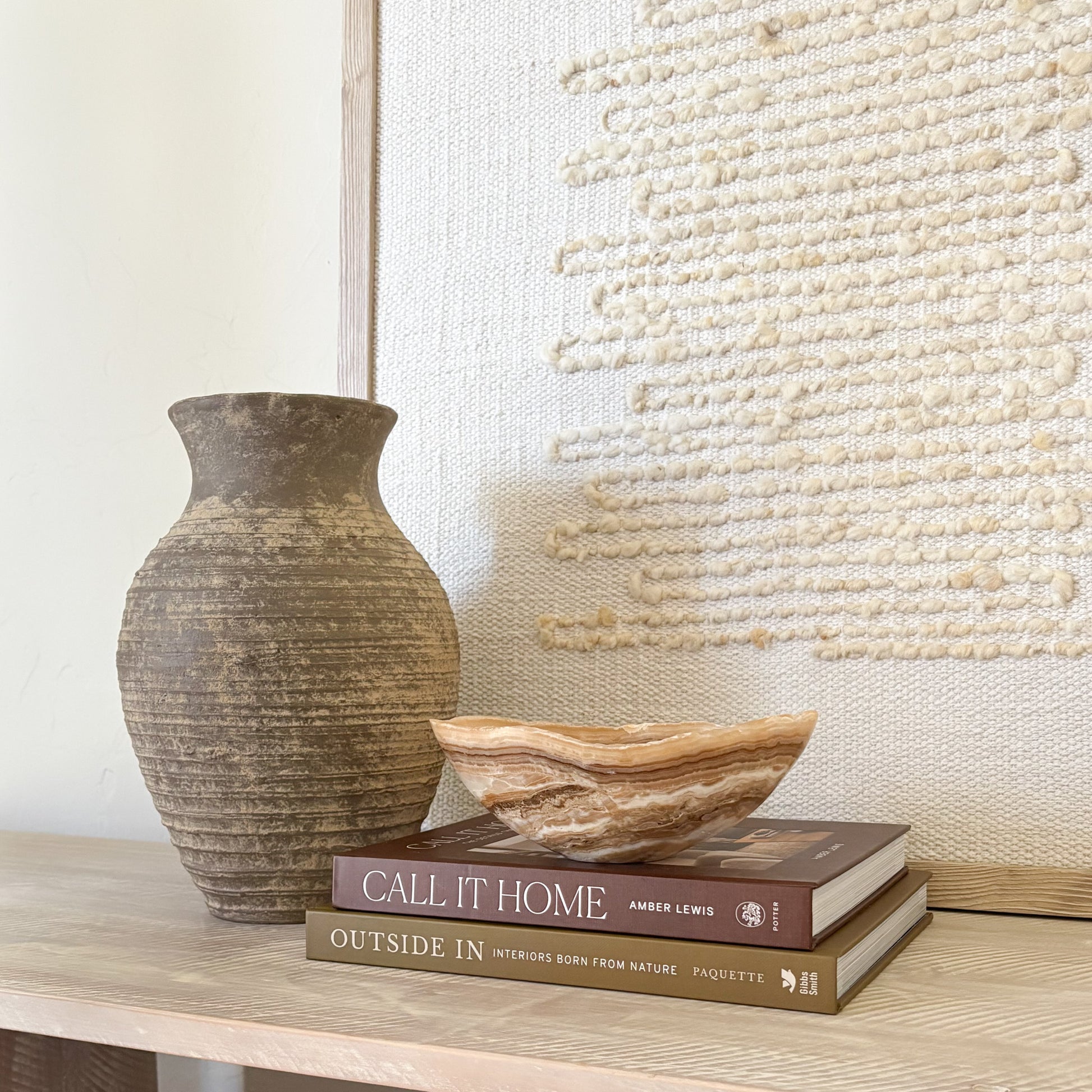 Small amber onyx bowl styled on wooden surface with neutral wall art