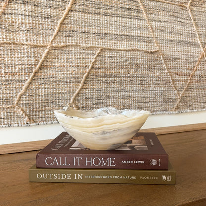 Small amber onyx stone bowl with smooth polished interior and layered cream, honey, and gray veining, handcrafted decorative bowl