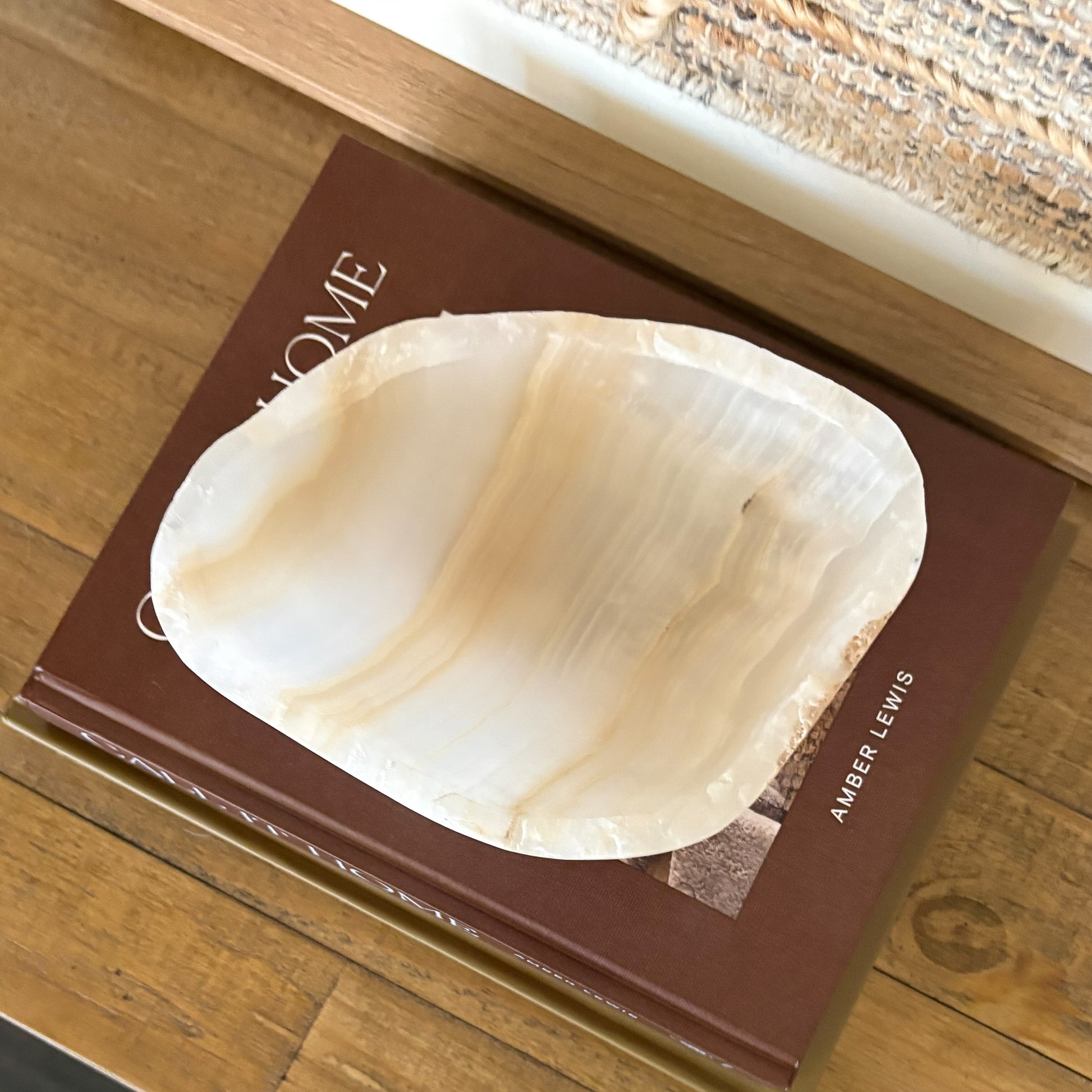 Small amber onyx bowl styled on wooden surface with neutral wall art
