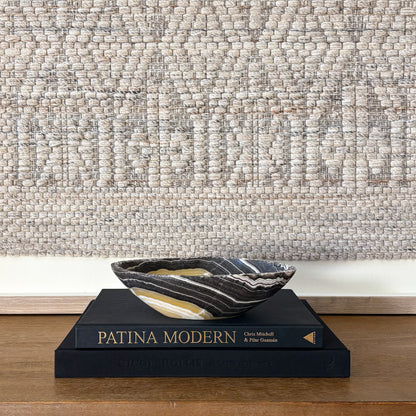 Small zebra onyx bowl styled on stacked design books in neutral modern interior