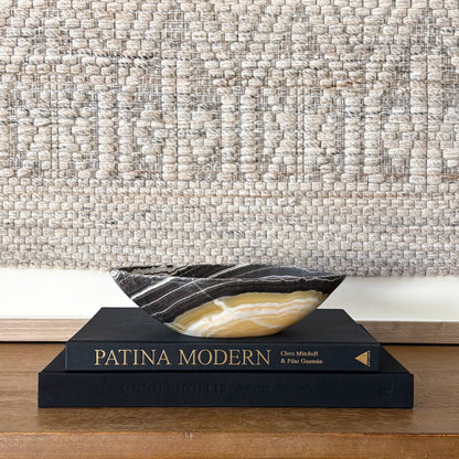 Small zebra onyx decorative bowl with natural striped stone pattern on wooden console