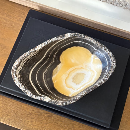 Small zebra onyx decorative bowl with natural striped stone pattern on wooden console