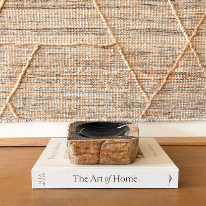 Stone petrified wood bowl styled with books and neutral interior design