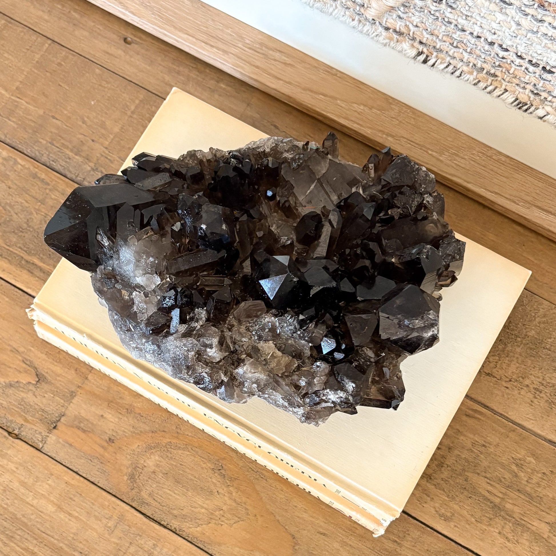 Smoky quartz crystal cluster styled as natural home decor on books