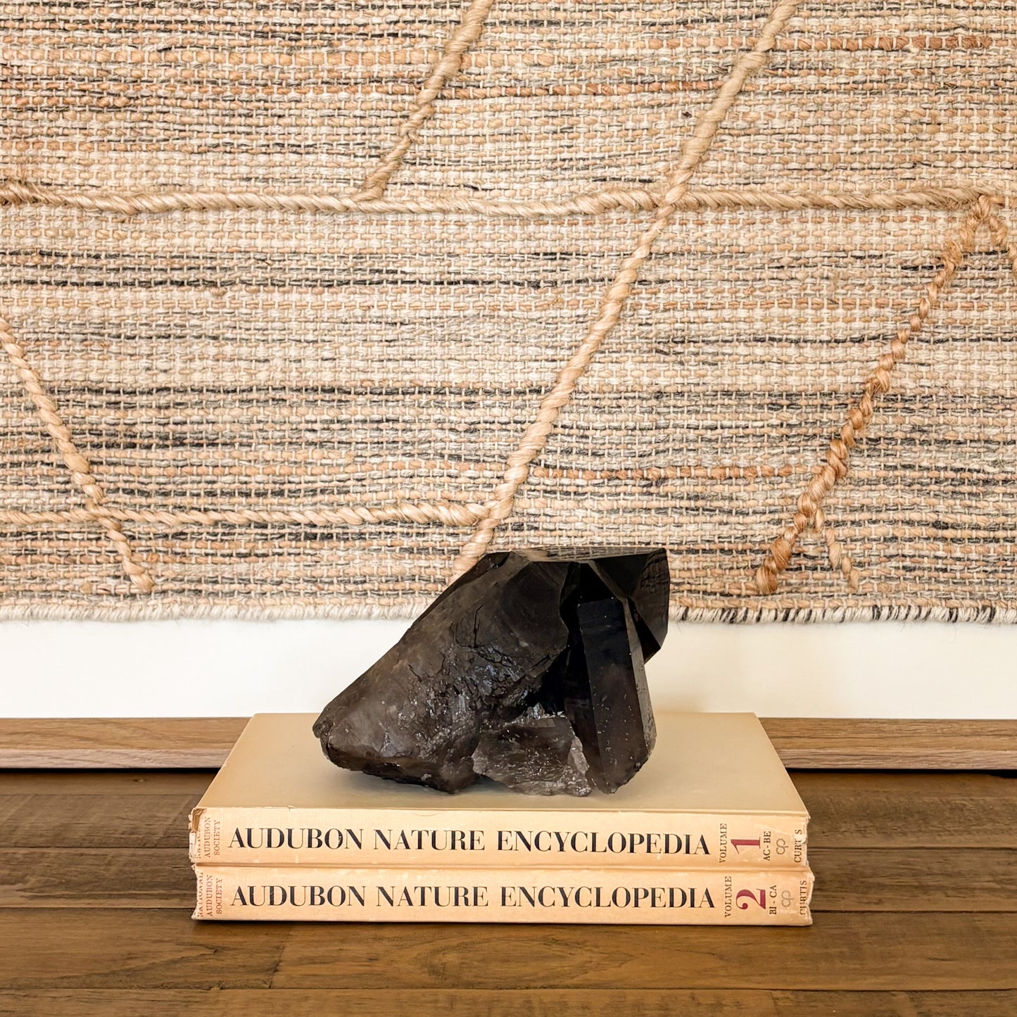 Smoky quartz crystal cluster styled as natural home decor on books