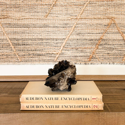 Large smoky quartz crystal cluster used as luxury home decor accent with rich brown natural gemstone points and polished mineral base.