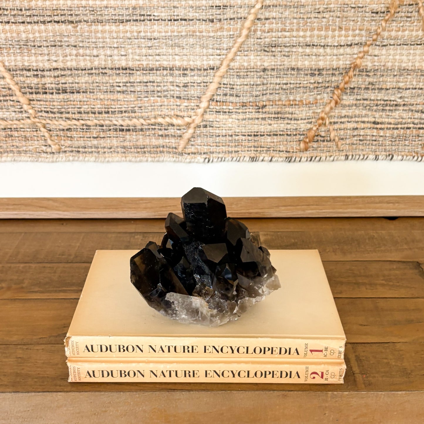 Natural smoky quartz crystal cluster displayed as elegant home decor on a shelf.