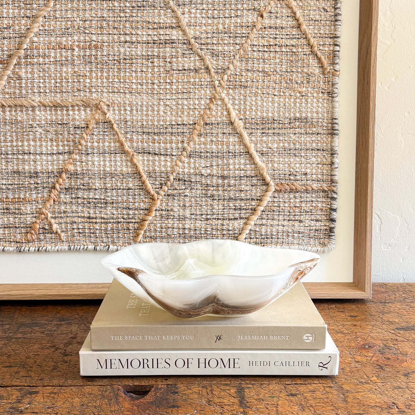 Hand-carved white onyx decorative bowl styled on coffee table with neutral home decor
