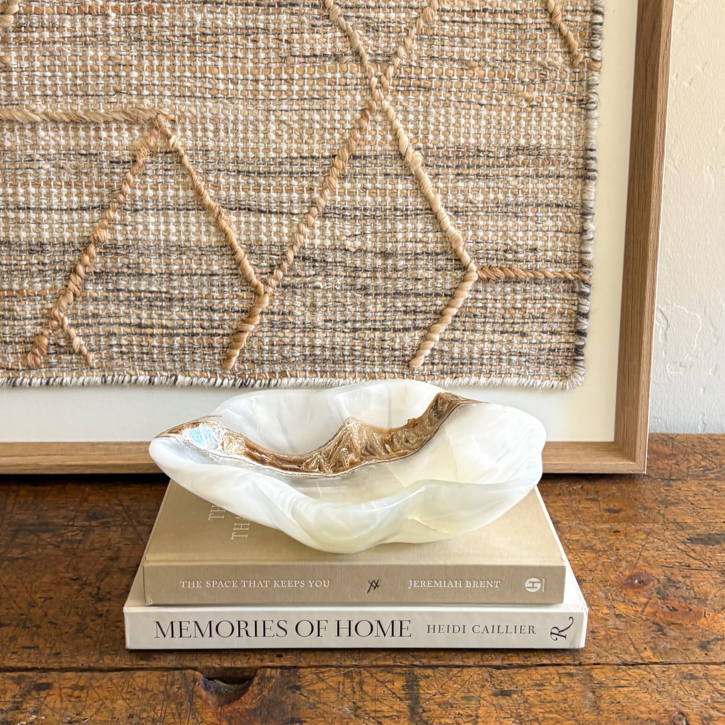 White onyx bowl handcrafted from natural stone displayed on stacked coffee table books
