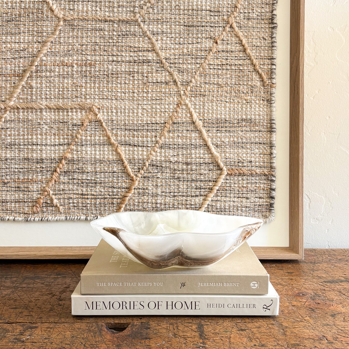 White onyx bowl handcrafted from natural stone displayed on stacked coffee table books