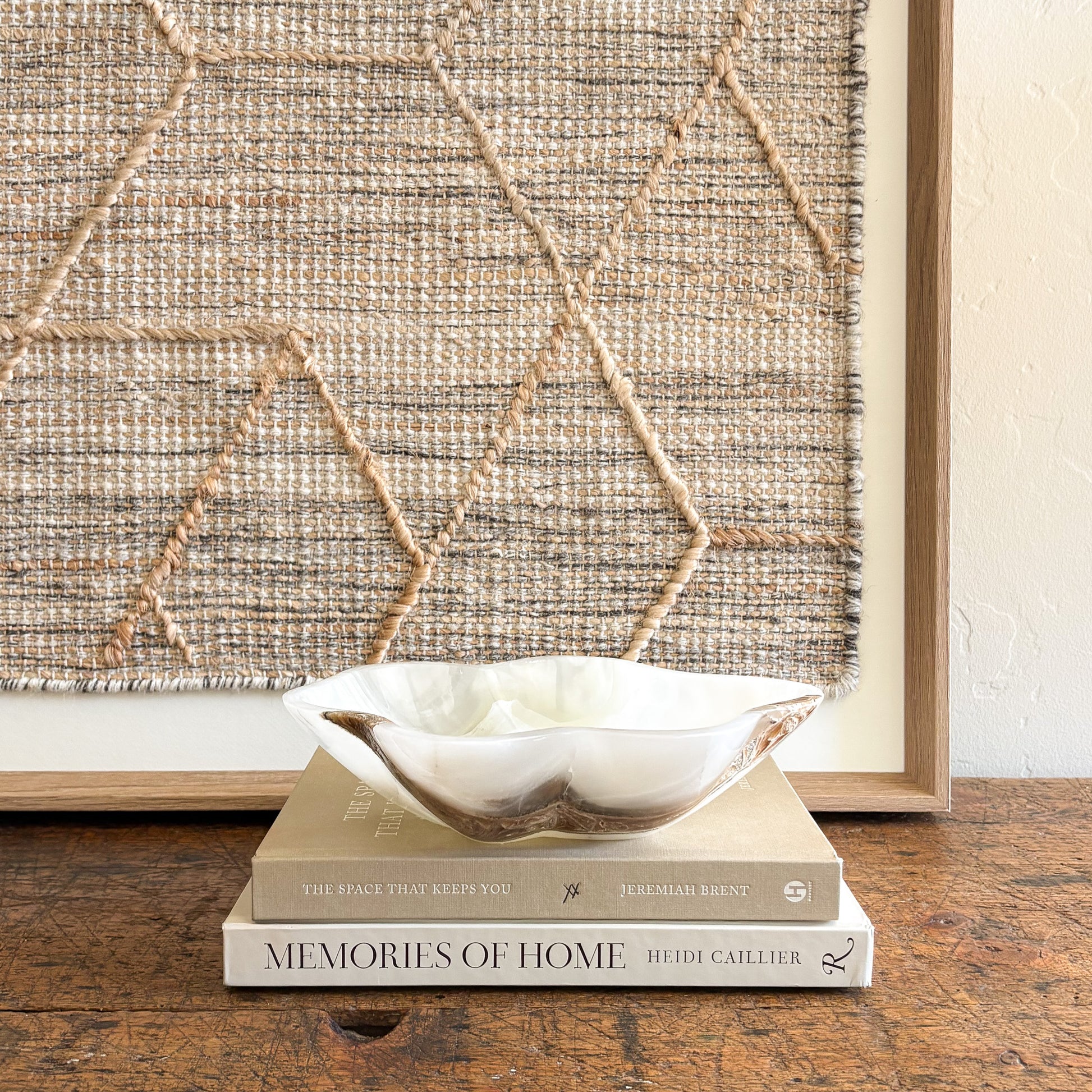 White onyx bowl handcrafted from natural stone displayed on stacked coffee table books