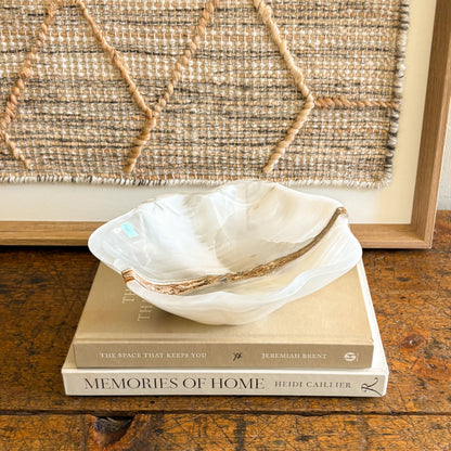 White onyx bowl styled on coffee table with design books luxury home decor