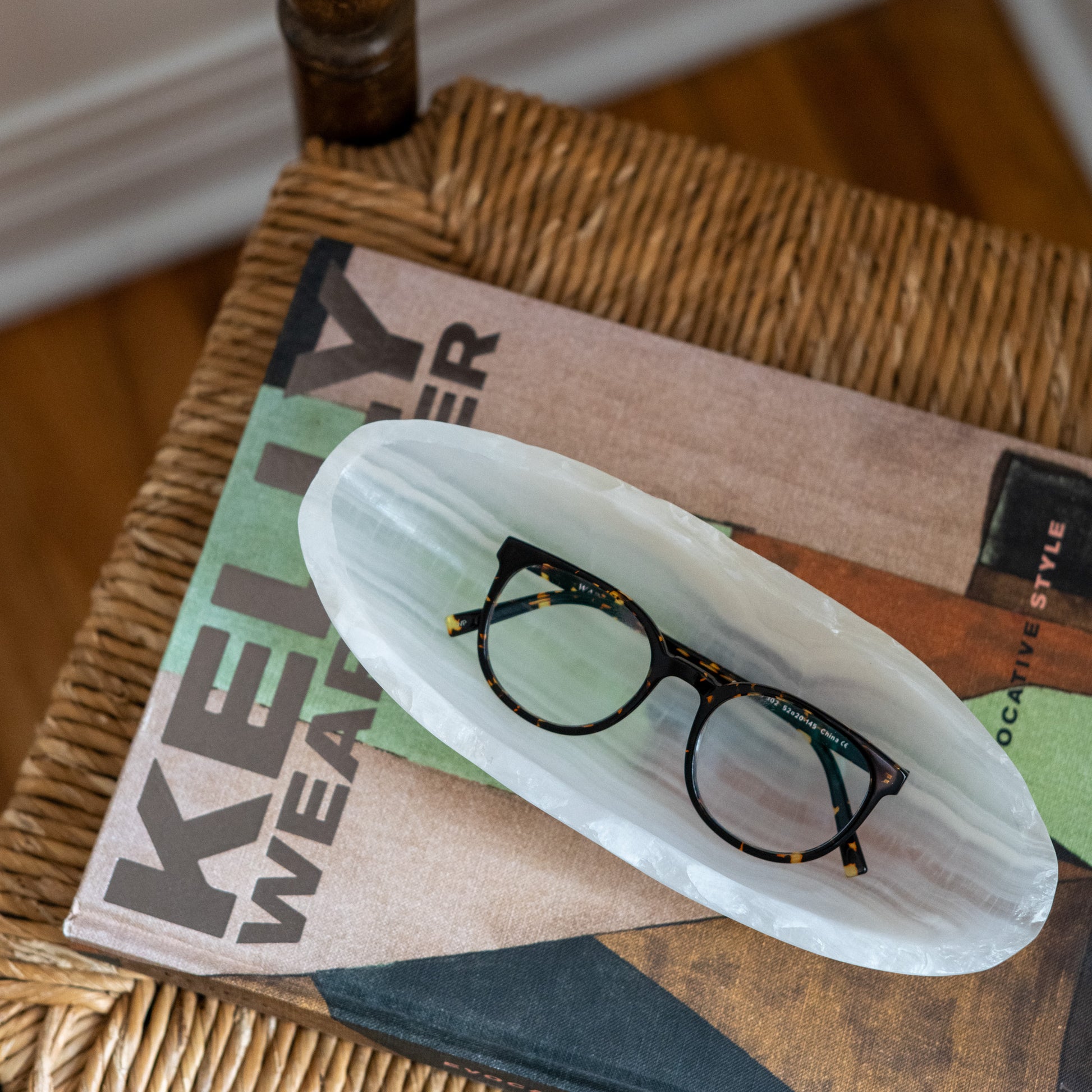 Small white onyx canoe bowl displayed on coffee table book for luxury home décor