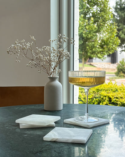 Handcrafted white onyx coaster set featuring natural stone veining and polished finish