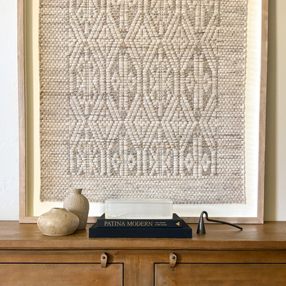 Rectangular white onyx lidded box styled on stacked books with neutral ceramic vases on wood console table