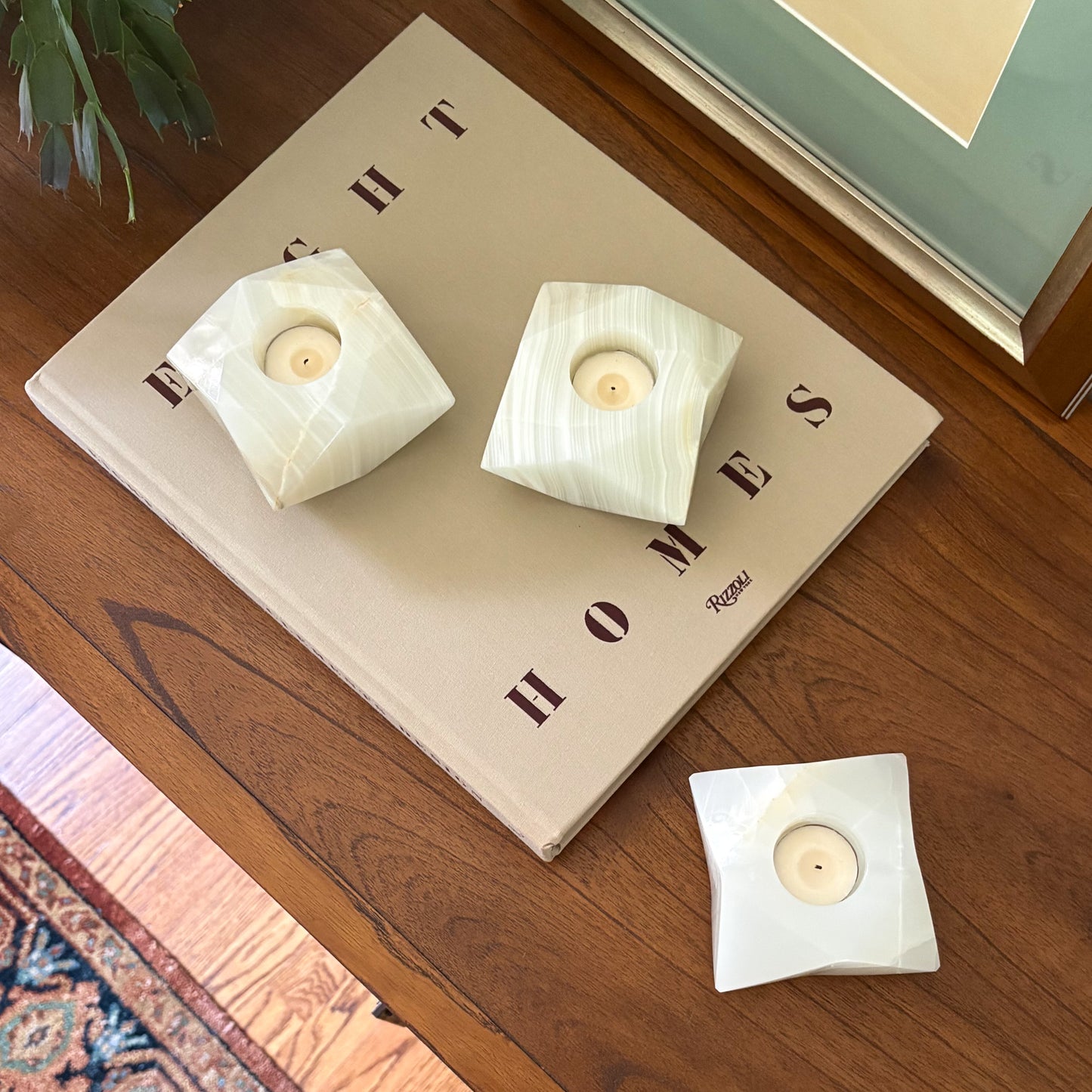 White onyx geometric candle holders displayed beside framed artwork