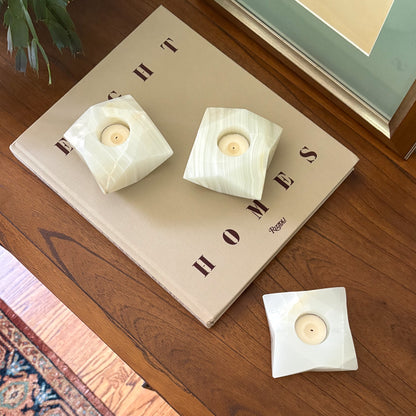 White onyx geometric candle holders displayed beside framed artwork