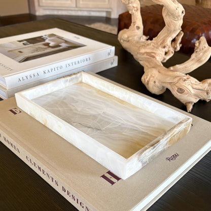 rectangular white onyx tray layered over books for modern coffee table styling