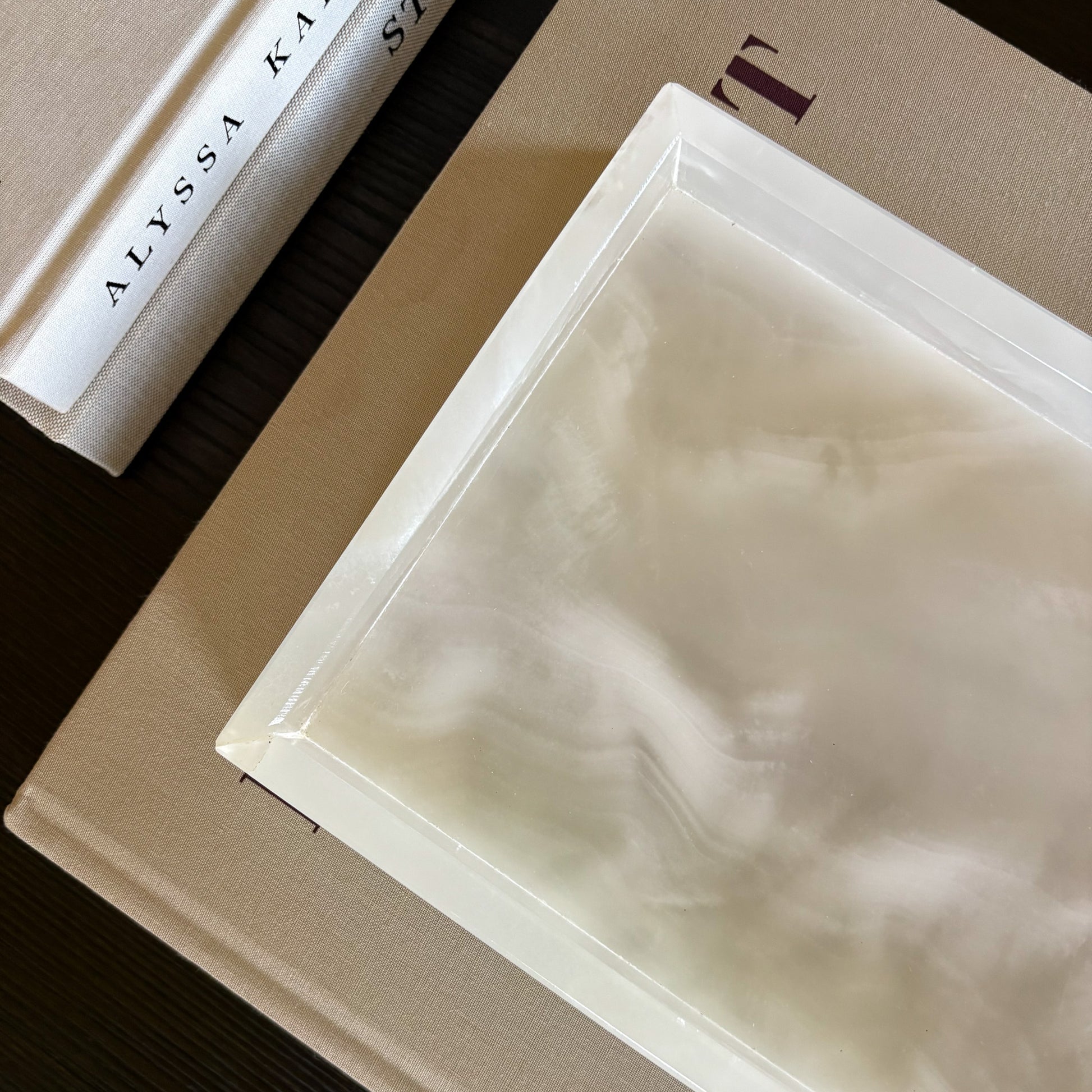 rectangular white onyx tray layered over books for modern coffee table styling