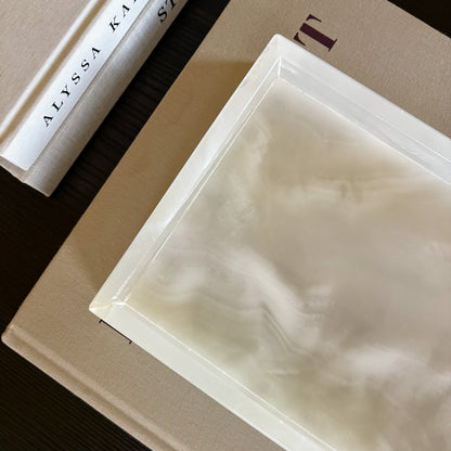 rectangular white onyx tray layered over books for modern coffee table styling