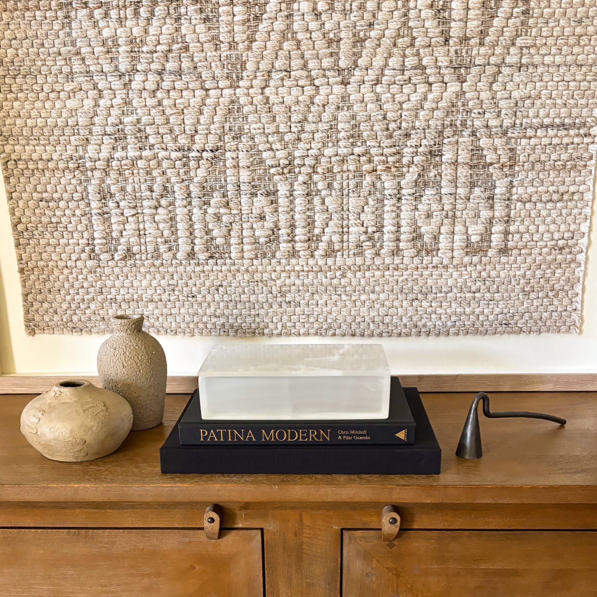 White onyx decorative storage box with lid styled on console table with textured wall art and ceramic pottery