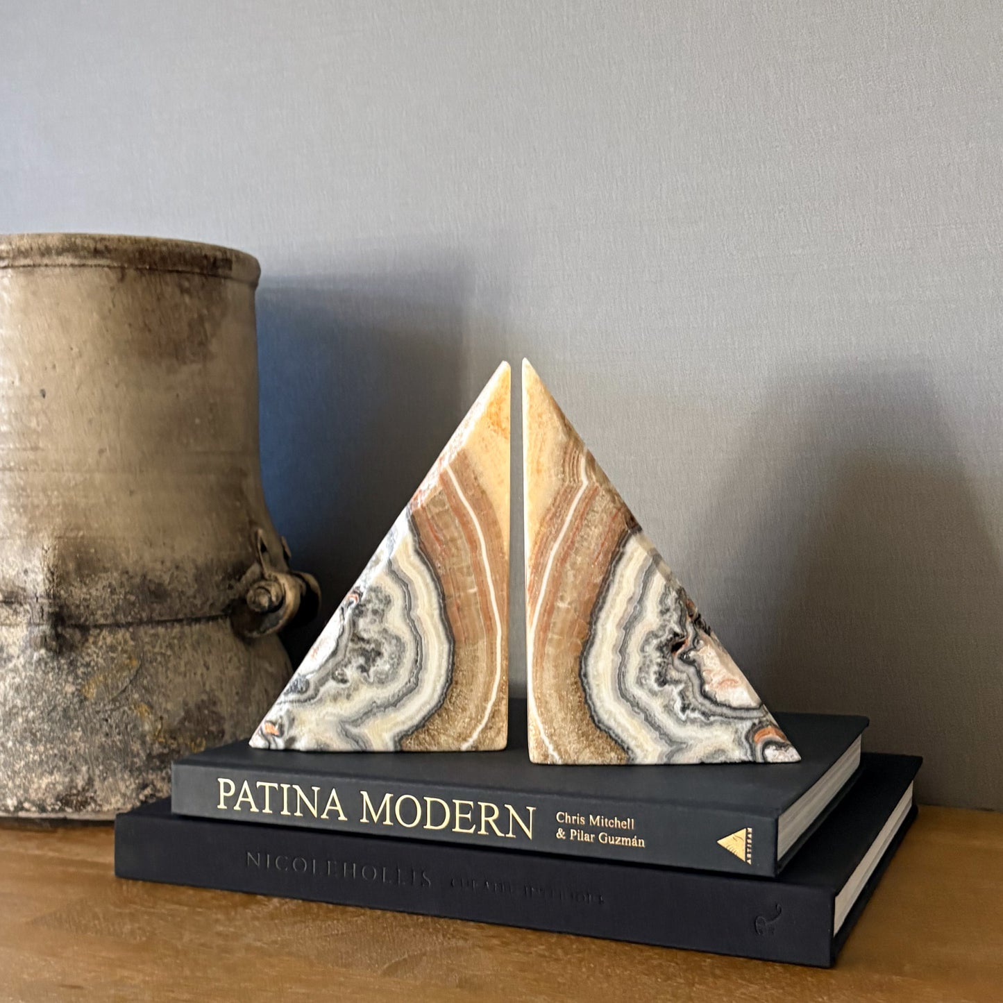 Hand carved zebra calcite bookend pair with natural brown, cream and gray banding displayed on modern coffee table books