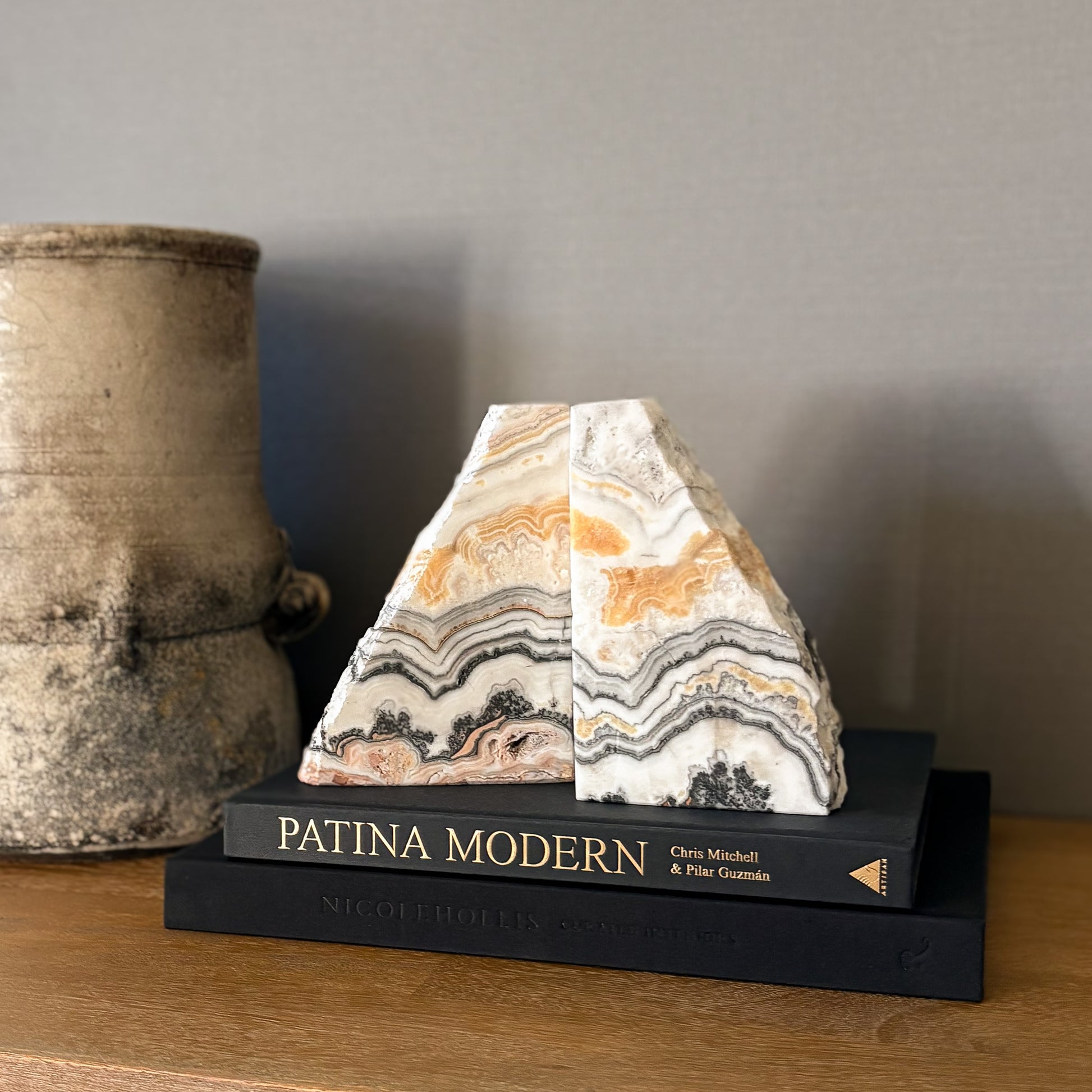 Natural zebra calcite stone bookends with warm neutral stripes on modern shelf