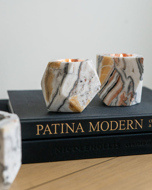 Hand-carved zebra calcite candle holders with natural cream, amber and charcoal banding