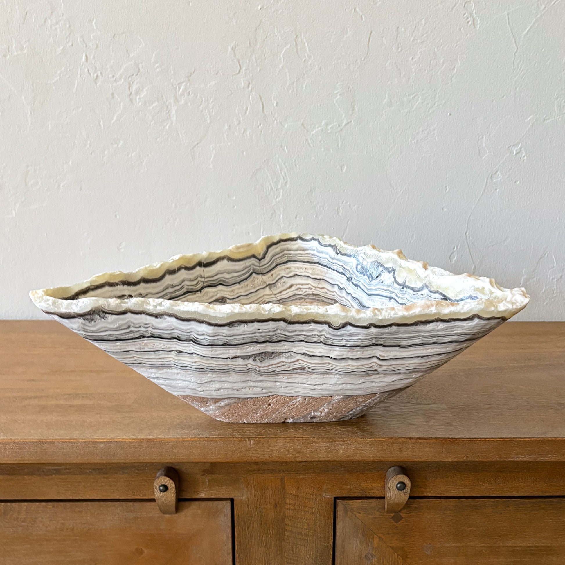 Natural zebra onyx statement bowl with layered mineral bands styled in modern neutral interior